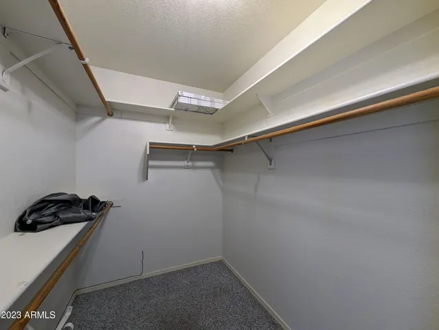 an empty room with a ceiling fan and carpet