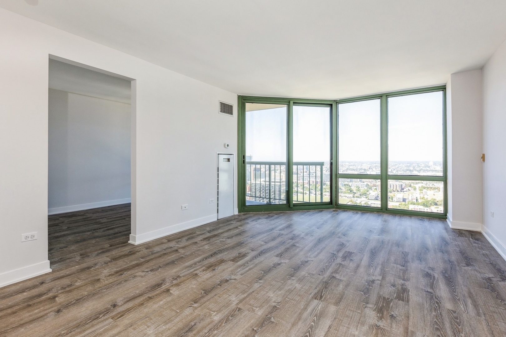 111 West Maple Street, Unit 3311 Chicago, IL 60610 - Photo 3 of 15 an empty room with wooden floor and balcony