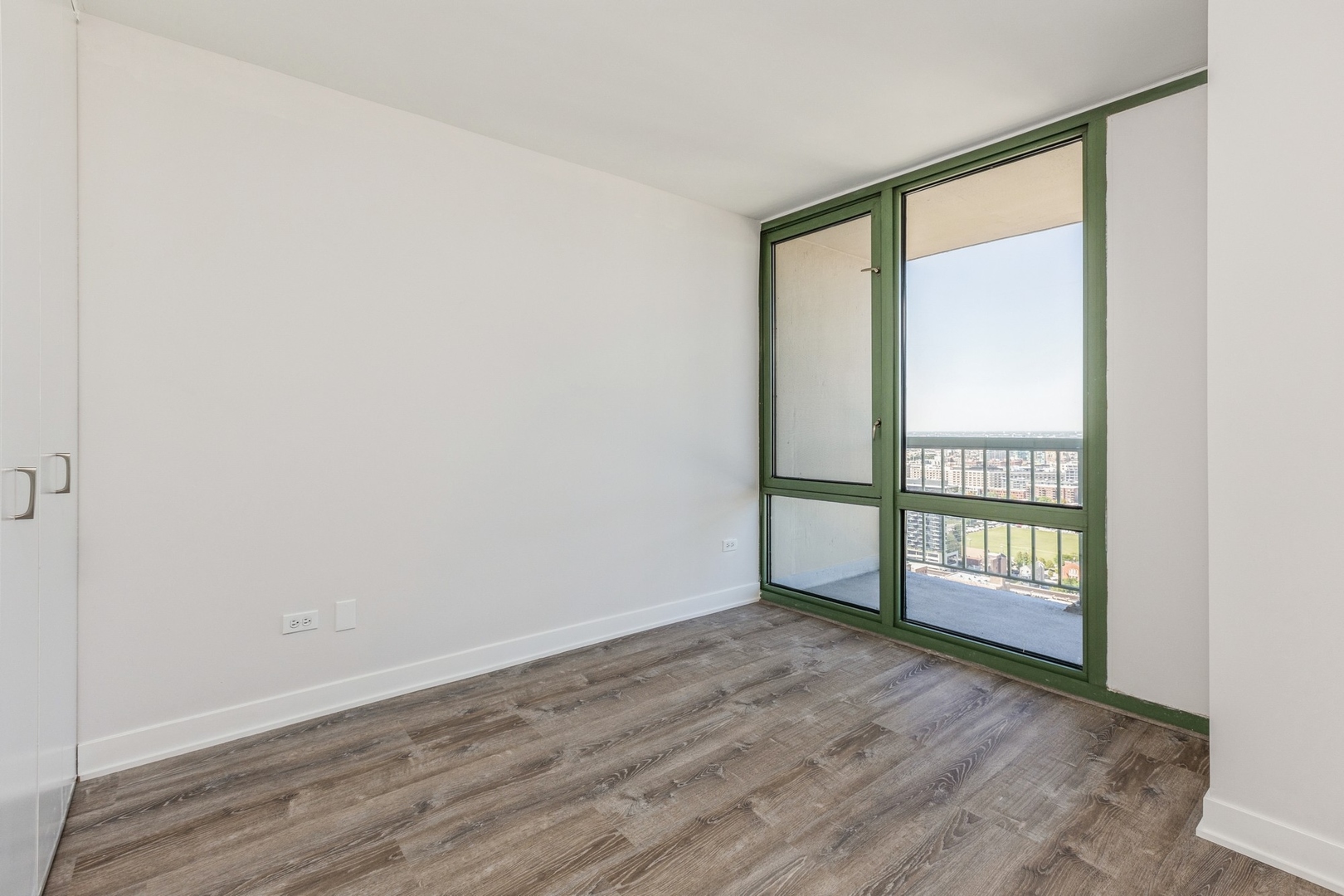 111 West Maple Street, Unit 3311 Chicago, IL 60610 - Photo 8 of 15 an empty room with wooden floor and windows