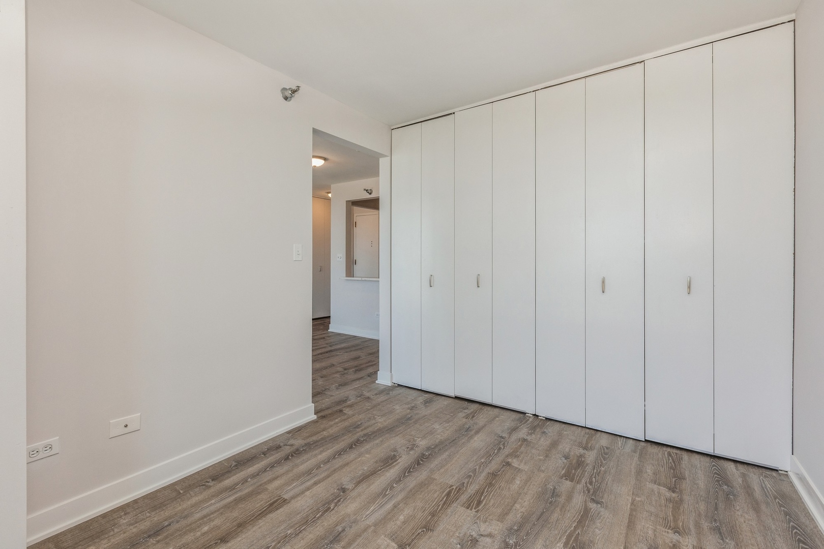 111 West Maple Street, Unit 3311 Chicago, IL 60610 - Photo 9 of 15 a view of an empty room with wooden floor
