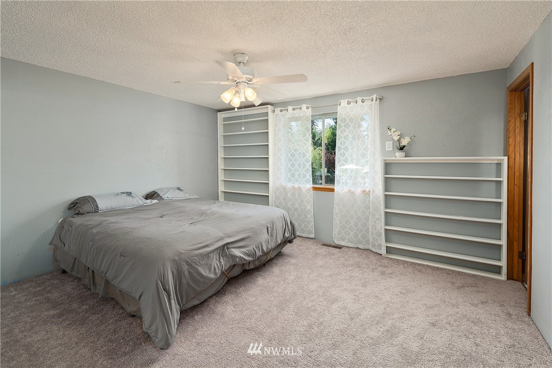 2603 171st Street Southeast Bothell, WA 98012 - Photo 18 of 37 a spacious bedroom with a bed and a chandelier