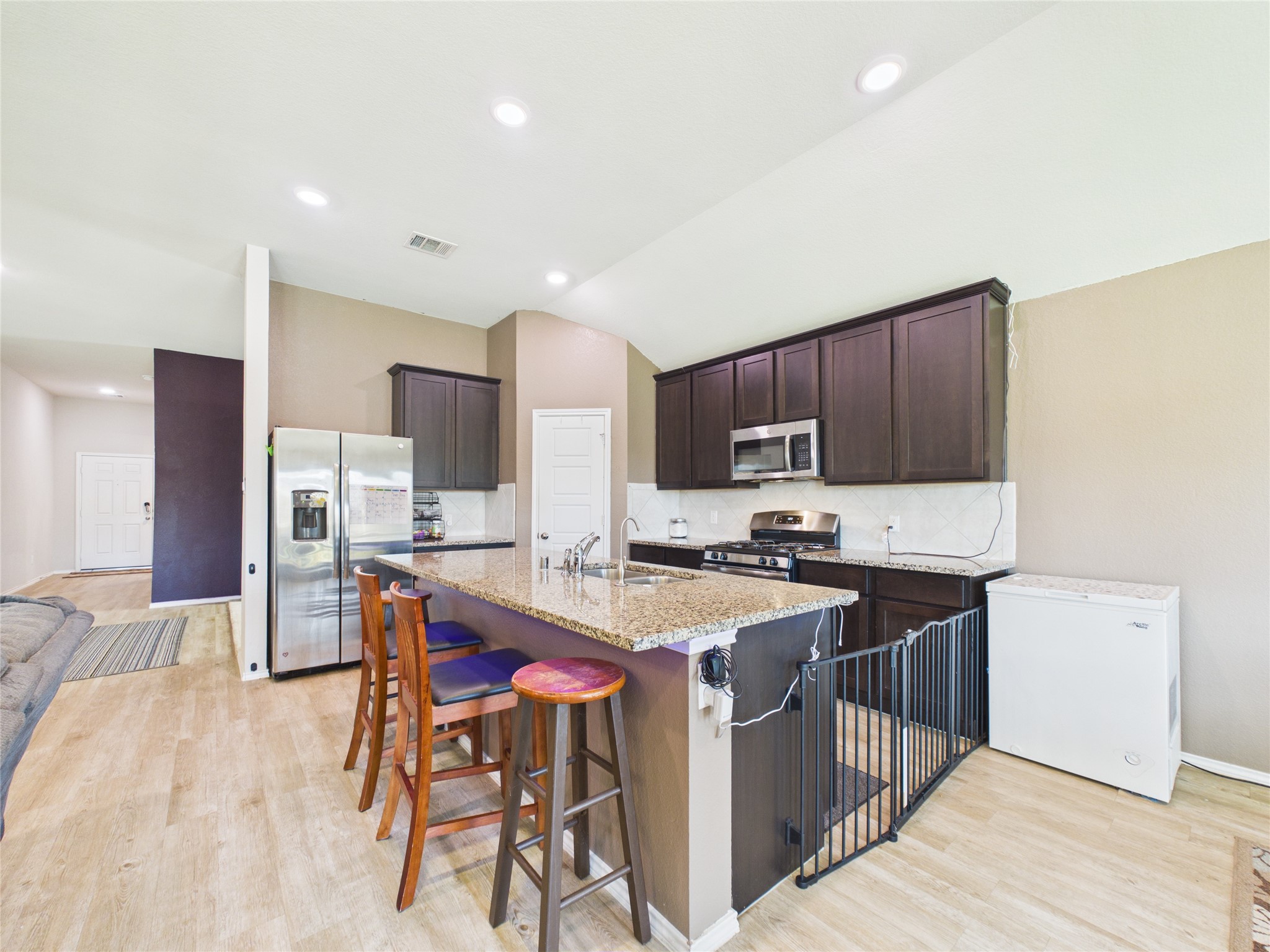 1237 Steed Bluff Drive Alvin, TX 77511 - Photo 19 of 50 a kitchen with stainless steel appliances granite countertop a table chairs sink refrigerator and cabinets