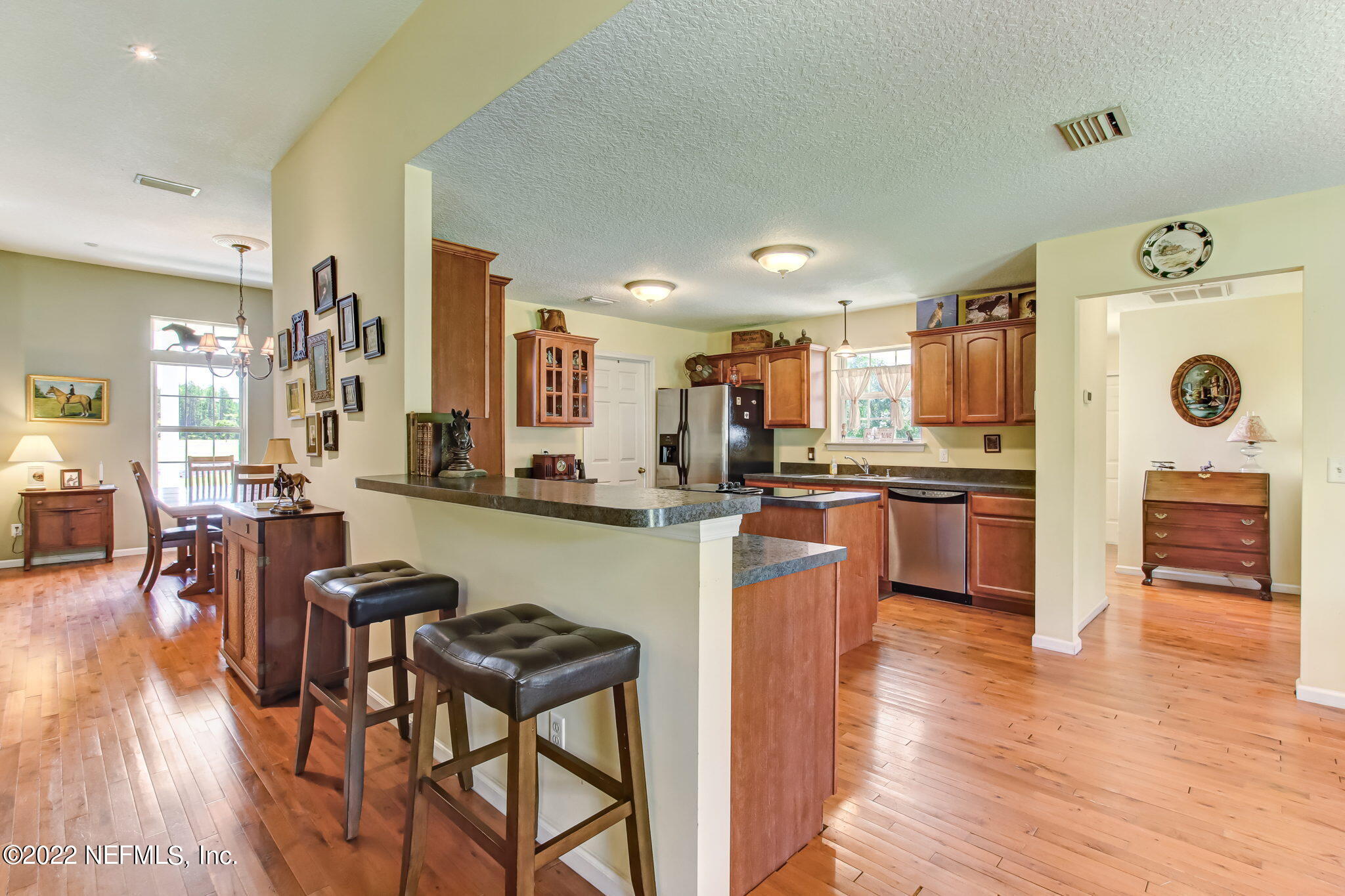 12410 County Road 121 Bryceville, FL 32009 - Photo 13 of 34 a kitchen with stainless steel appliances granite countertop a refrigerator a stove top oven and a dining table with wooden floor