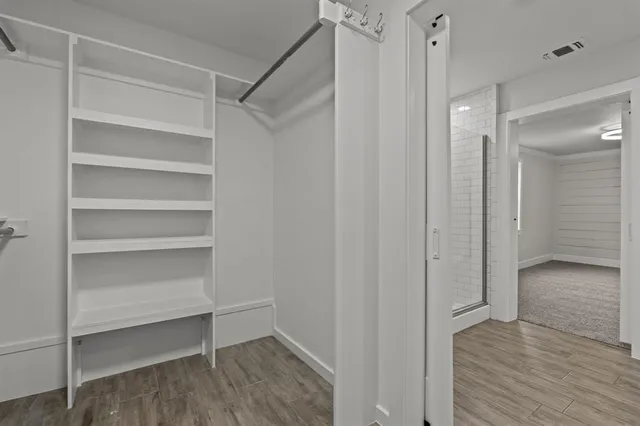 a view of walk in closet with empty racks