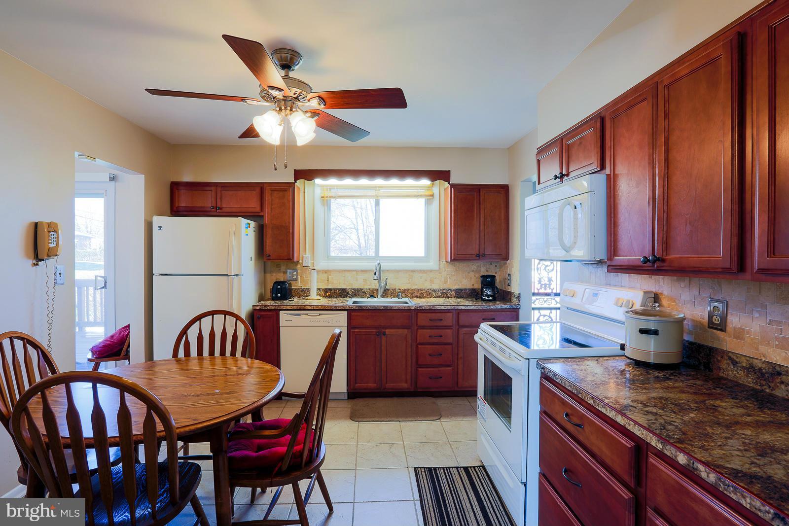 3834 Cherrybrook Road Randallstown, MD 21133 - Photo 9 of 30 a kitchen with granite countertop a dining table chairs stainless steel appliances and cabinets