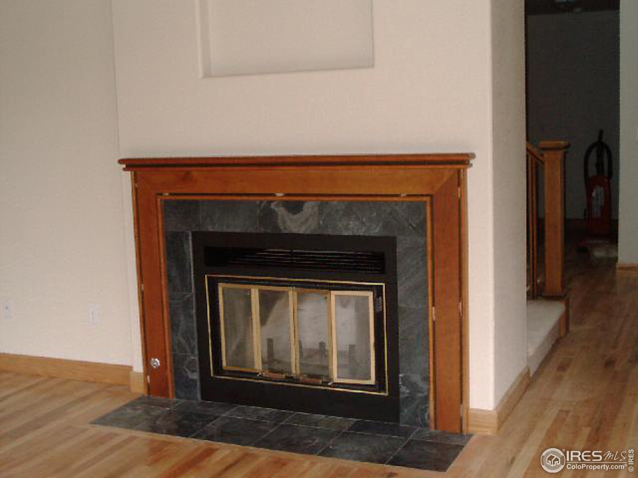 7225 Four Rivers Road Boulder, CO 80301 - Photo 4 of 6 a an empty room with wooden floor a fireplace