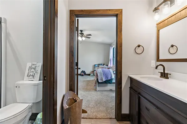 a en suite bathroom with a granite countertop sink and a mirror
