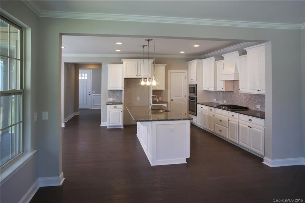 132 Helton Lane, Unit 38 Fort Mill, SC 29708 - Photo 3 of 23 a kitchen with stainless steel appliances kitchen island granite countertop a stove a sink and a refrigerator