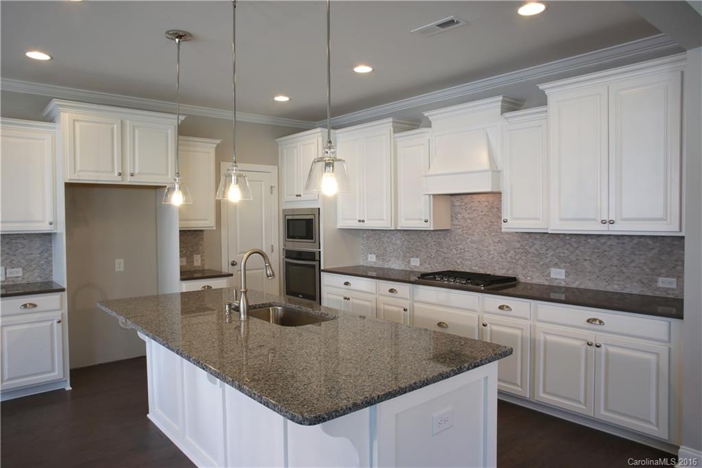 132 Helton Lane, Unit 38 Fort Mill, SC 29708 - Photo 4 of 23 a kitchen with kitchen island granite countertop a sink a center island and cabinets