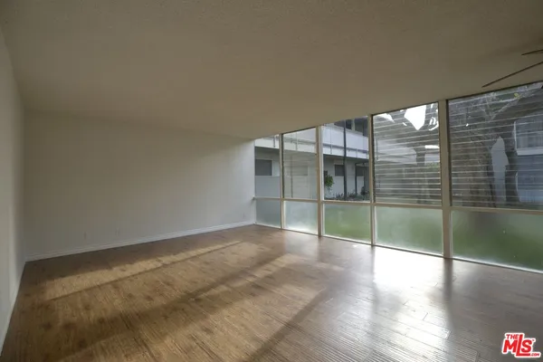 an empty room with wooden floor and door