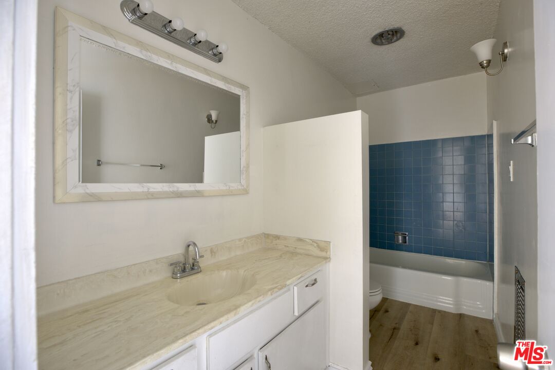 11131 Rose Avenue, Unit 13 Los Angeles, CA 90034 - Photo 11 of 17 a bathroom with a granite countertop sink and a mirror
