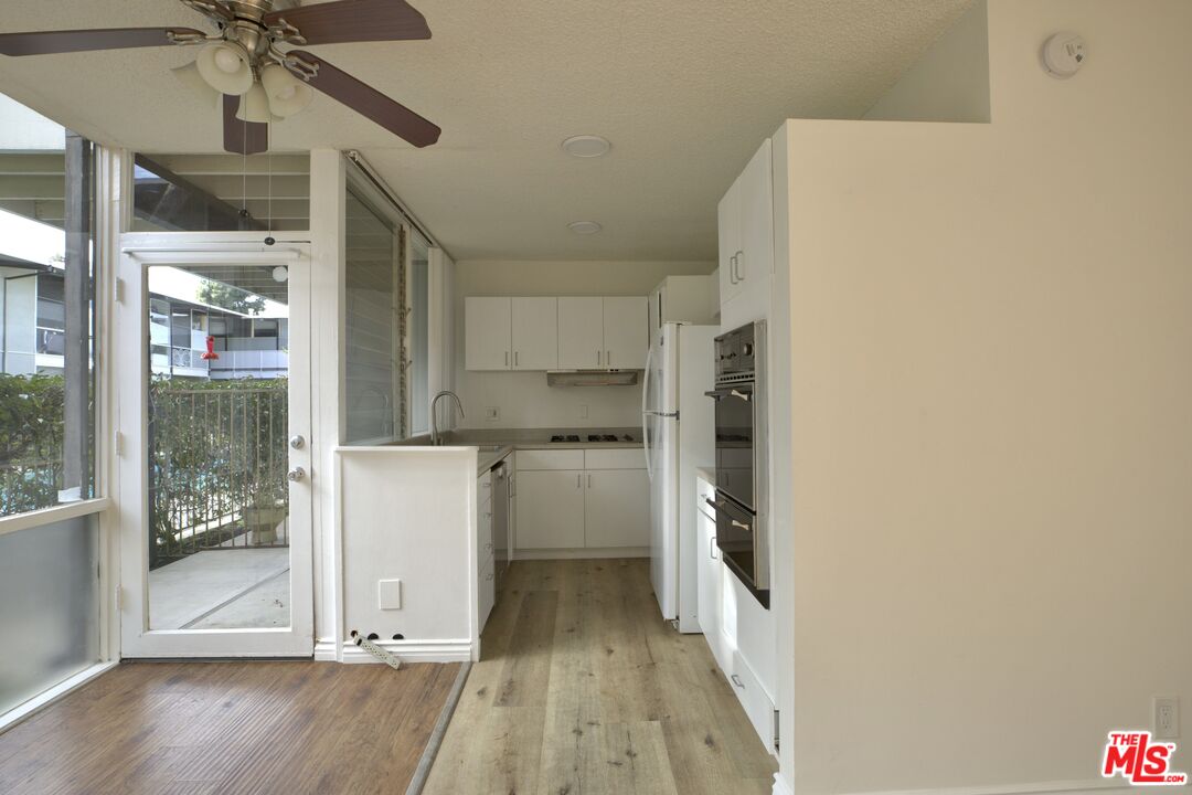 11131 Rose Avenue, Unit 13 Los Angeles, CA 90034 - Photo 3 of 17 a kitchen with a refrigerator a sink and cabinets