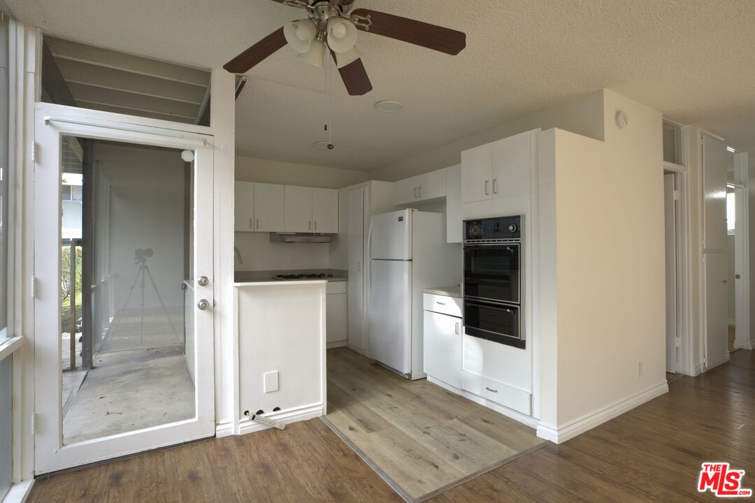 11131 Rose Avenue, Unit 13 Los Angeles, CA 90034 - Photo 4 of 17 a view of a kitchen with a refrigerator and a stove top oven