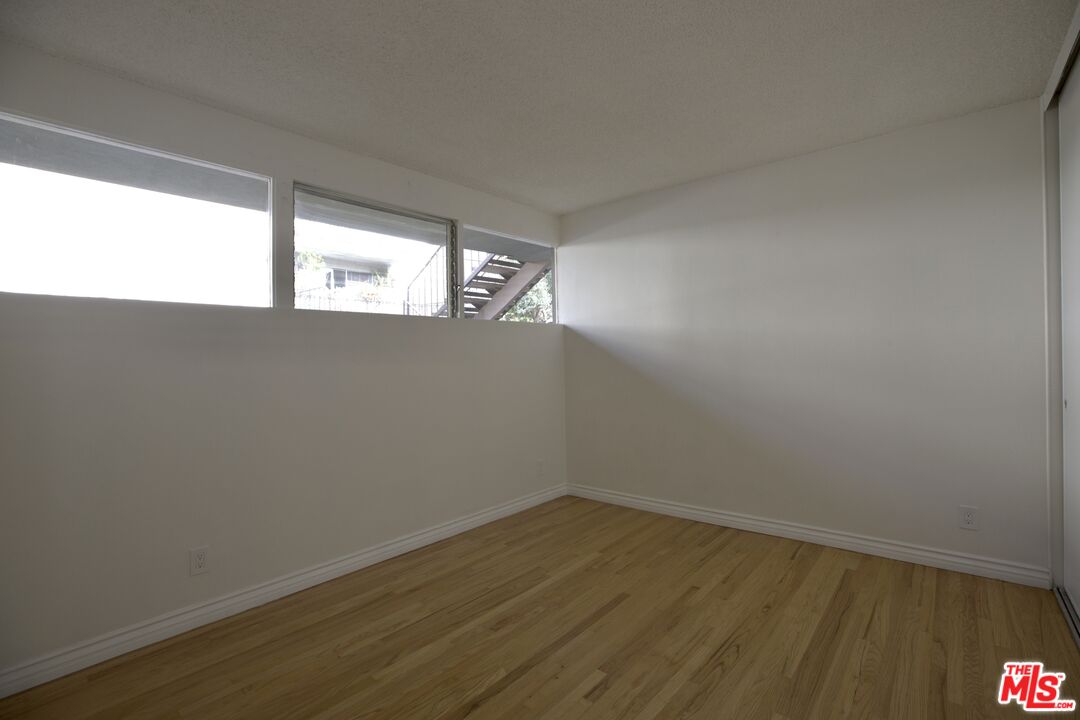 11131 Rose Avenue, Unit 13 Los Angeles, CA 90034 - Photo 6 of 17 a view of empty room with wooden floor and fan
