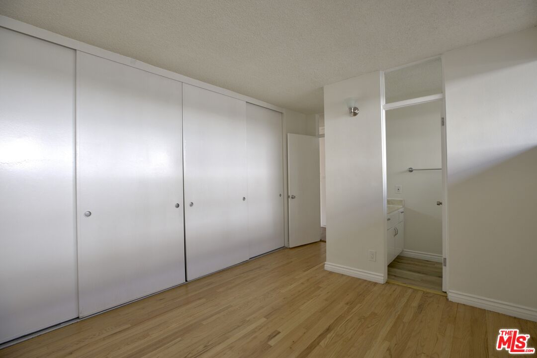 11131 Rose Avenue, Unit 13 Los Angeles, CA 90034 - Photo 7 of 17 a view of an empty room with wooden floor and closet area