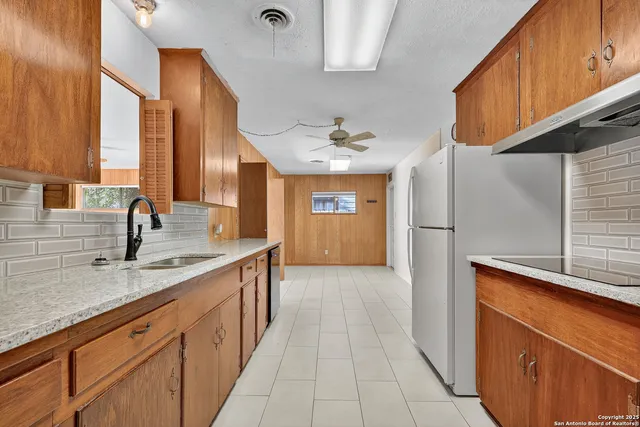 a kitchen with stainless steel appliances granite countertop a sink and a refrigerator
