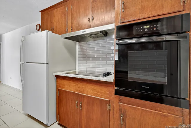 a kitchen with appliances and a refrigerator