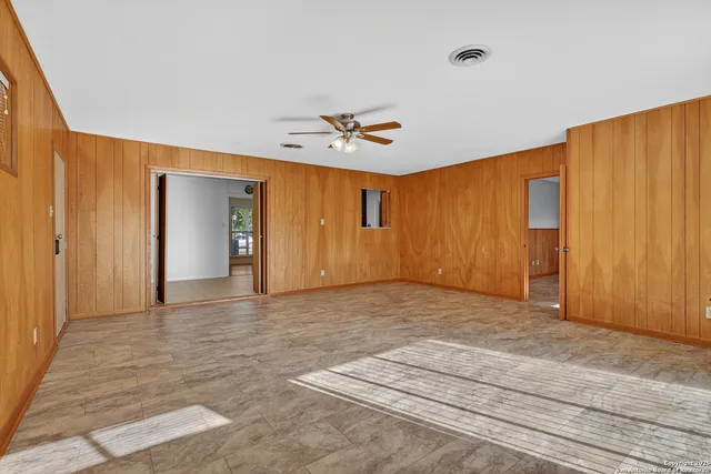 a view of an empty room with a ceiling fan