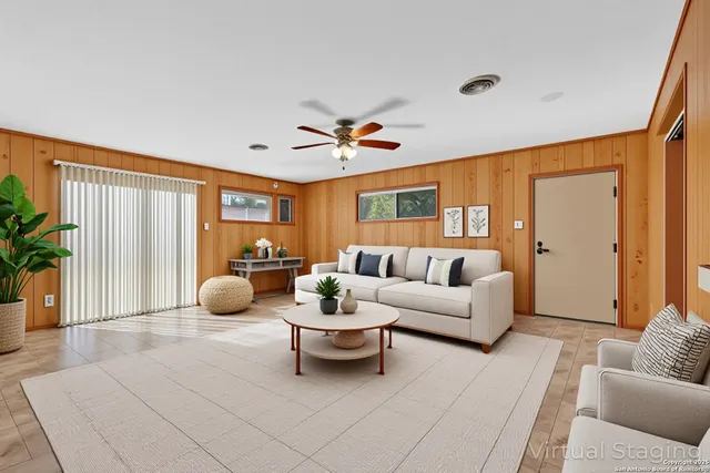 a living room with furniture a chandelier and a large window