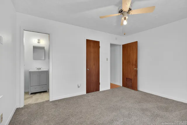 a view of a room with a ceiling fan and closet area