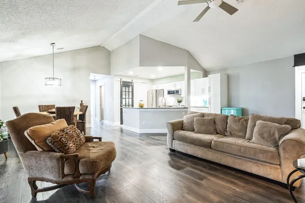 a living room with furniture and a wooden floor