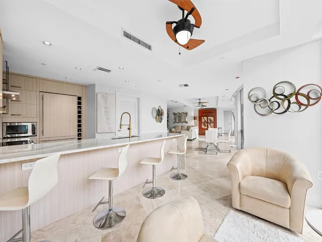 a living room with furniture kitchen view and a kitchen island