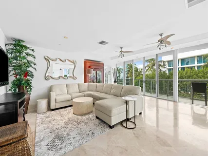 a living room with furniture and a large window with potted plants