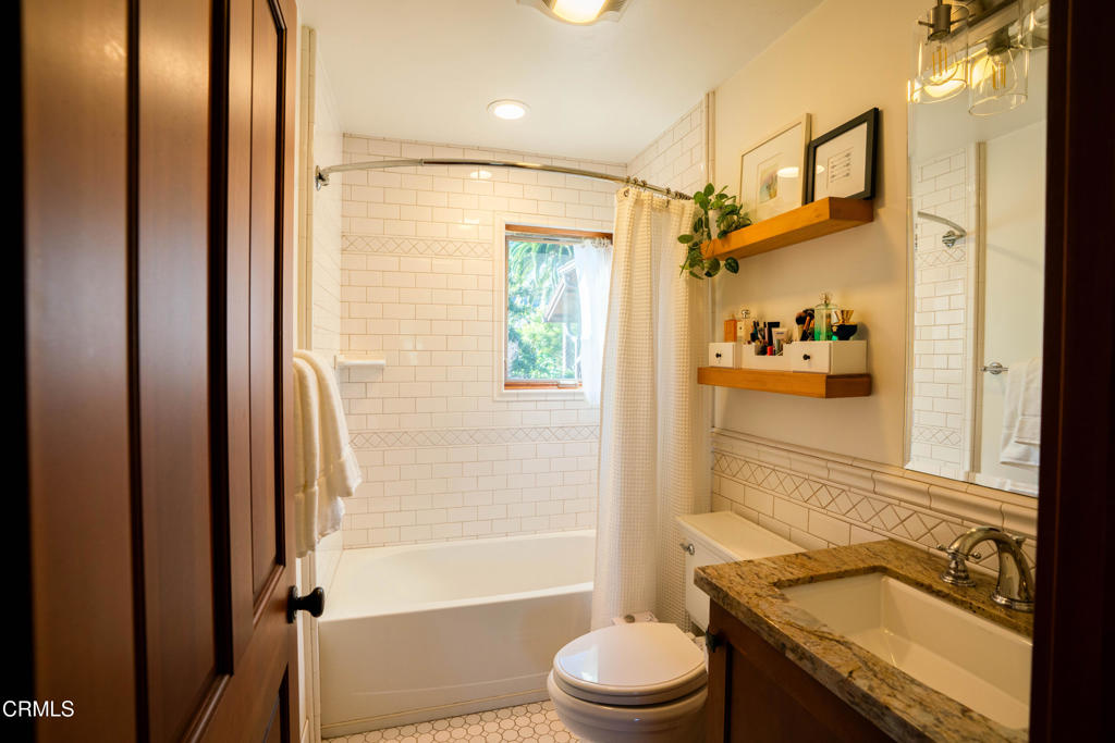 316 West Ortega Street, Unit B Santa Barbara, CA 93101 - Photo 17 of 19 a bathroom with a granite countertop sink toilet and shower