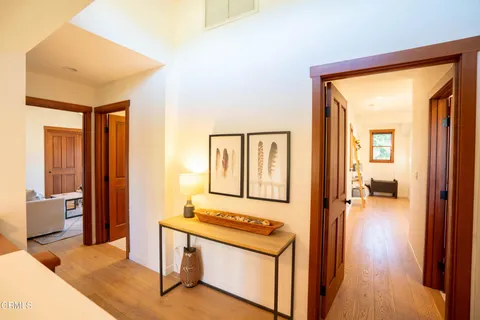 a view of a hallway with wooden floor and a living room
