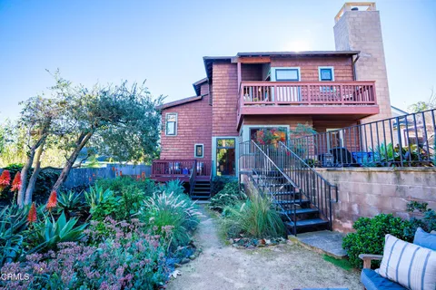 a view of a small yard in front of a house with wooden fence