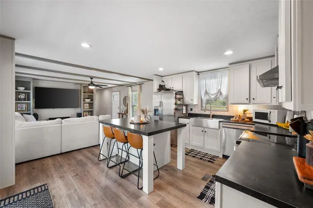 a kitchen with a sink cabinets and wooden floor