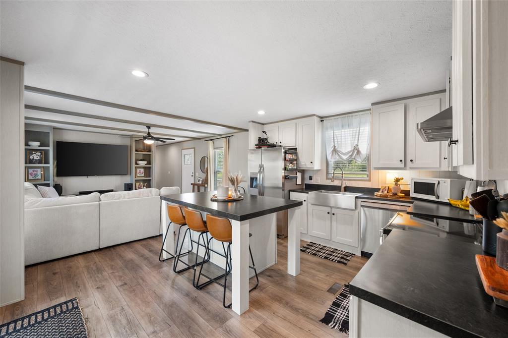 421 Garitty Street Frost, TX 76641 - Photo 11 of 25 a kitchen with a sink cabinets and wooden floor