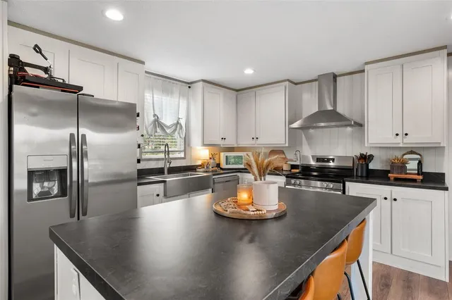 a kitchen with a sink a stove and chairs