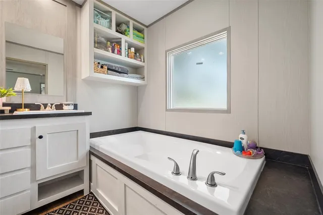 a bathroom with a tub sink and mirror