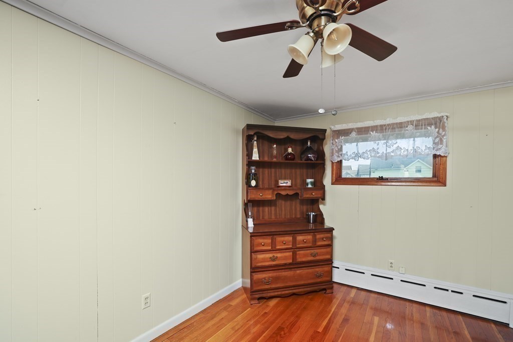 382 America Street Fall River, MA 02721 - Photo 14 of 25 an empty room with wooden floor chandelier fan and windows
