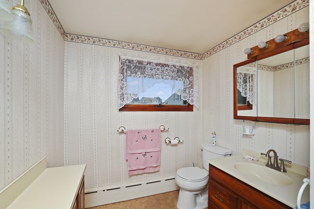 382 America Street Fall River, MA 02721 - Photo 23 of 25 a bathroom with a sink mirror vanity and toilet