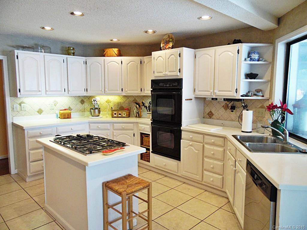 988 Cove Point Lane Tega Cay, SC 29708 - Photo 9 of 22 a kitchen with granite countertop a sink stove and refrigerator