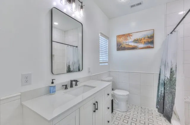 a bathroom with a sink toilet and a mirror