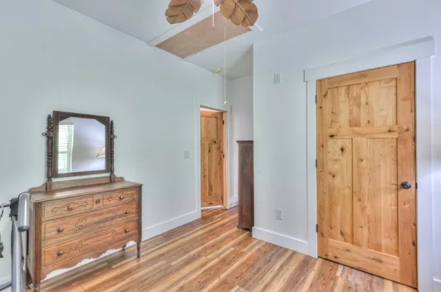 a view of a hallway with wooden floor and front door