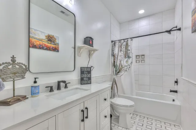 a bathroom with a granite countertop sink a toilet and shower