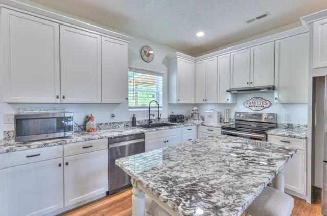 a kitchen with a stove a sink a refrigerator and cabinets