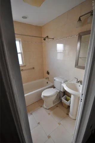a bathroom with a sink a toilet a mirror and shower