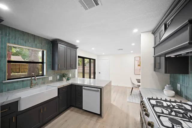 a kitchen with a refrigerator a stove top oven a sink and dishwasher