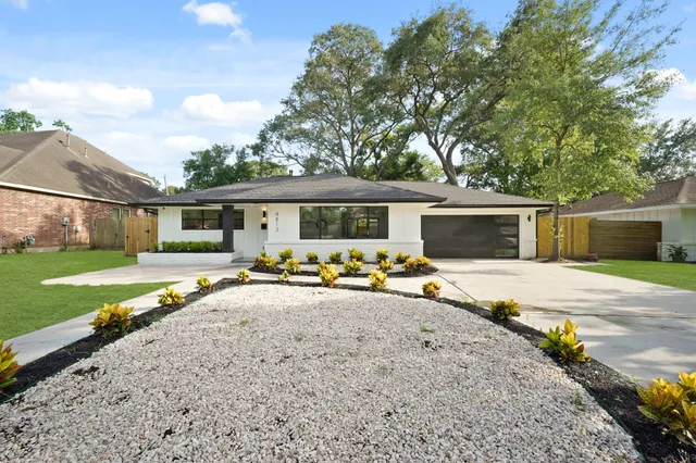 a view of a house with backyard and a tree