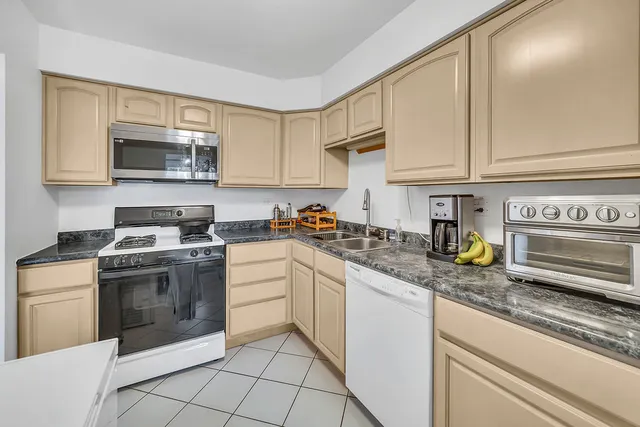 a kitchen with appliances a sink and cabinets