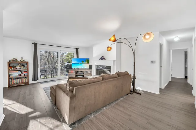 a living room with furniture a flat screen tv and a large window