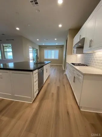 a large kitchen with stainless steel appliances granite countertop a stove and a sink