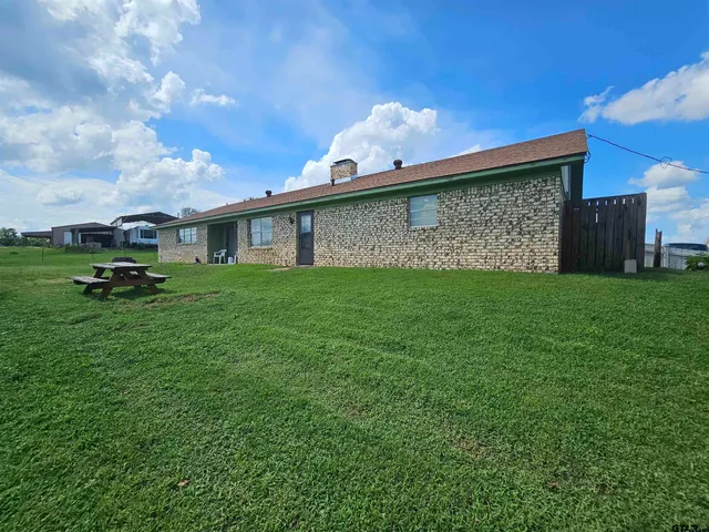 a backyard of a house with table and chairs