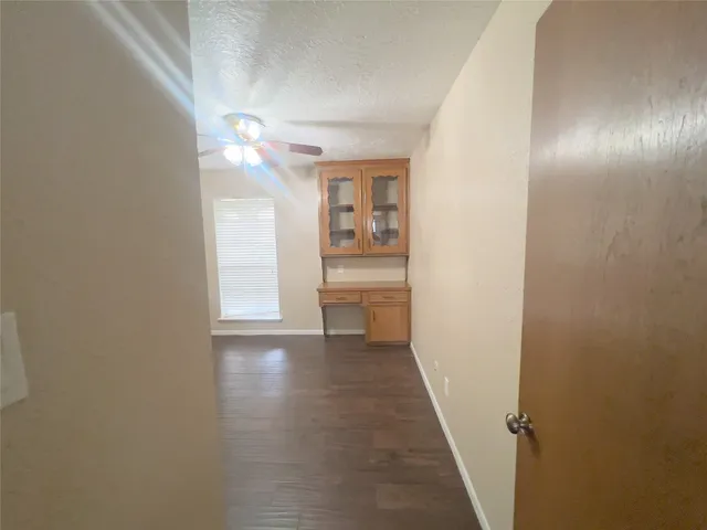 a view of empty room with kitchen and window