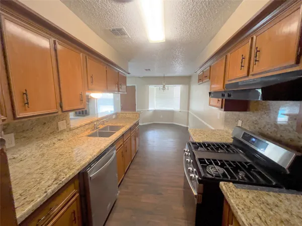 a kitchen with granite countertop a stove and a sink